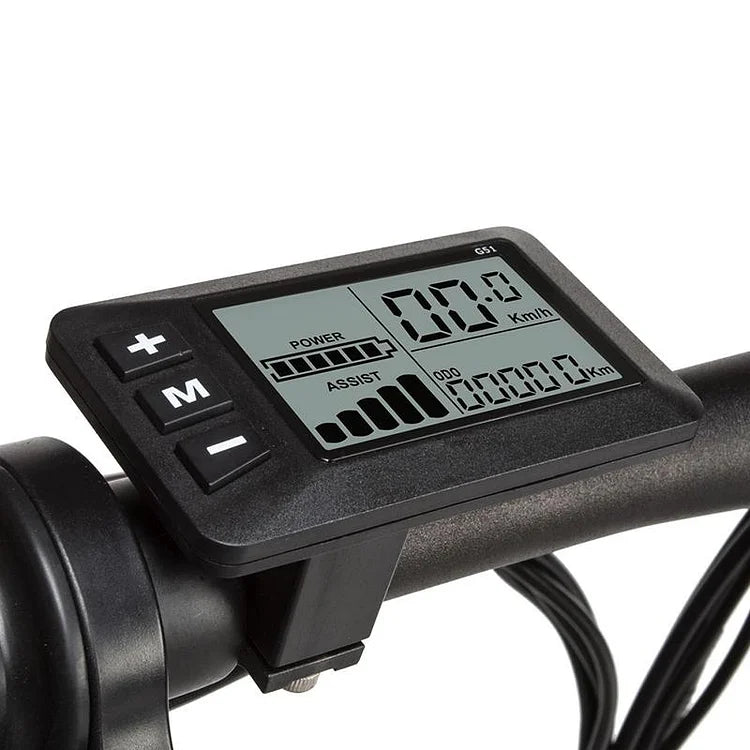 Close-up of an electronic bike display mounted on handlebars, showing speed, power, assist level, battery status, and distance traveled. The display has plus, minus, and mode buttons on the side.