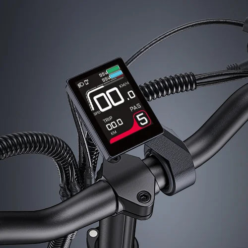 Close-up of an electric bike’s handlebar, featuring a digital display showing speed, battery level, trip distance, pedal assist level, and other ride information. The background is a plain gradient gray.
