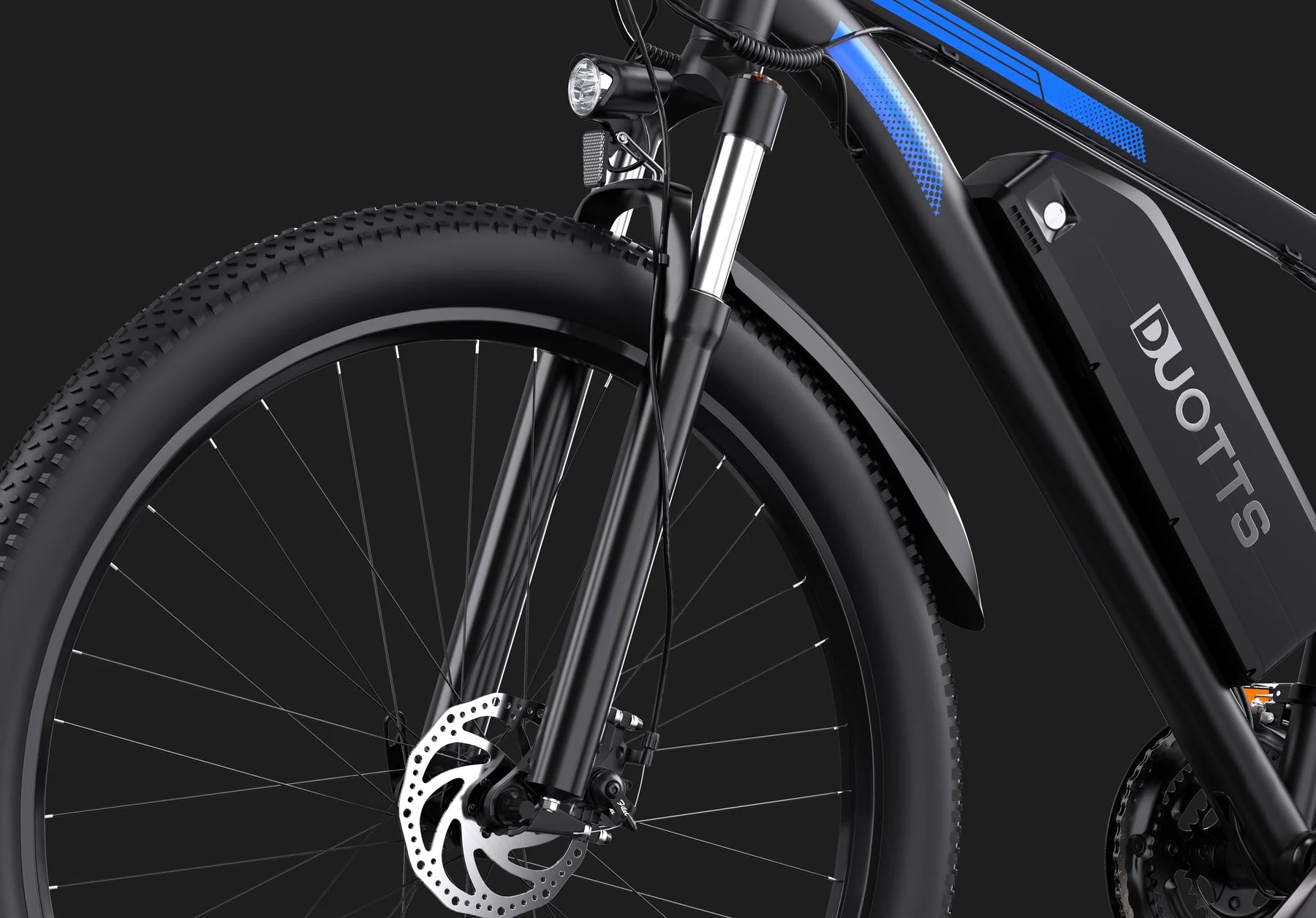 Close-up of the front wheel and fork of a black DUOTTS electric bicycle, highlighting the disc brake, suspension, battery pack, and part of the frame against a dark background.