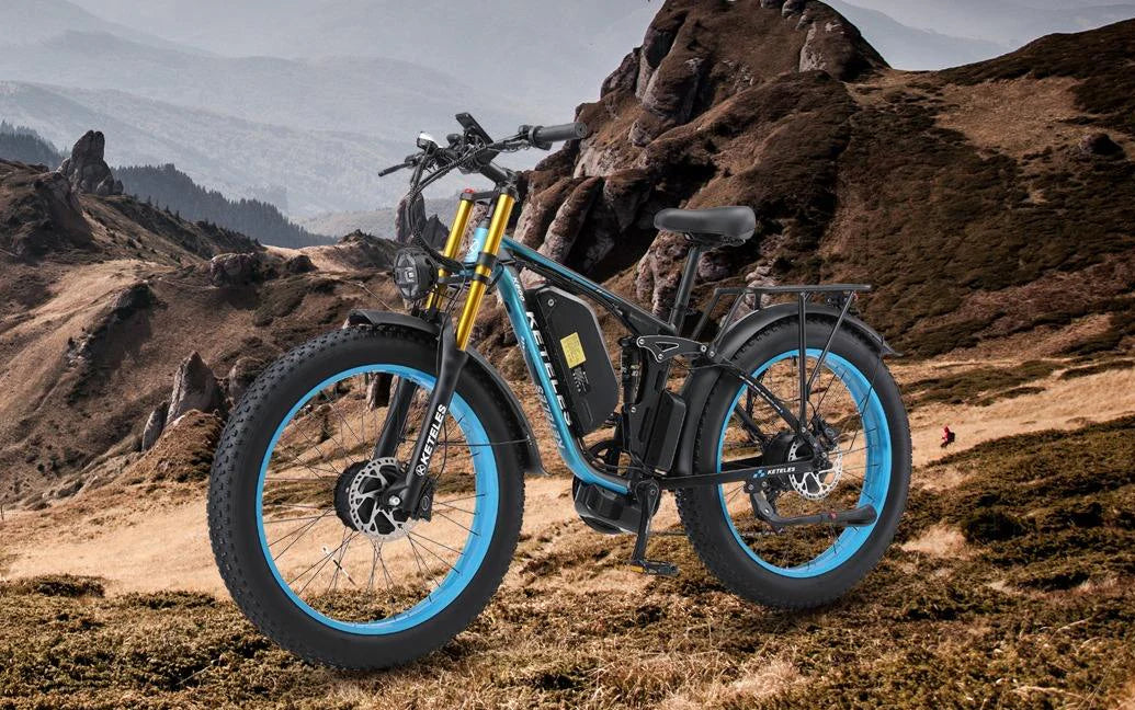 Electric fat tire bike with blue rims parked on a rocky mountain landscape under cloudy sky