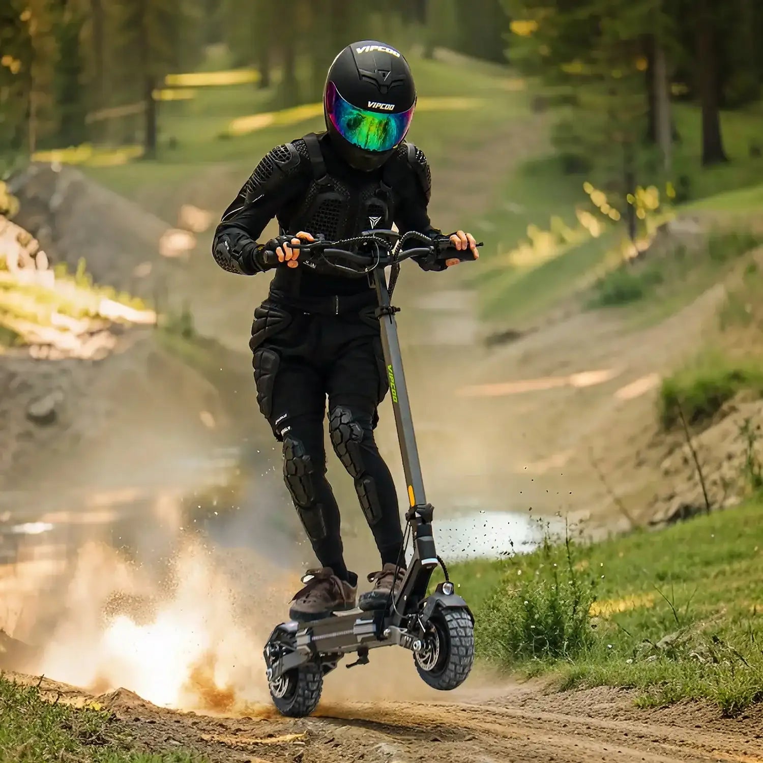 A rider in protective gear and a black helmet takes the Vipcoo VS6 1000W Electric Scooter off-road, kicking up dust on a dirt trail bordered by grass and trees.