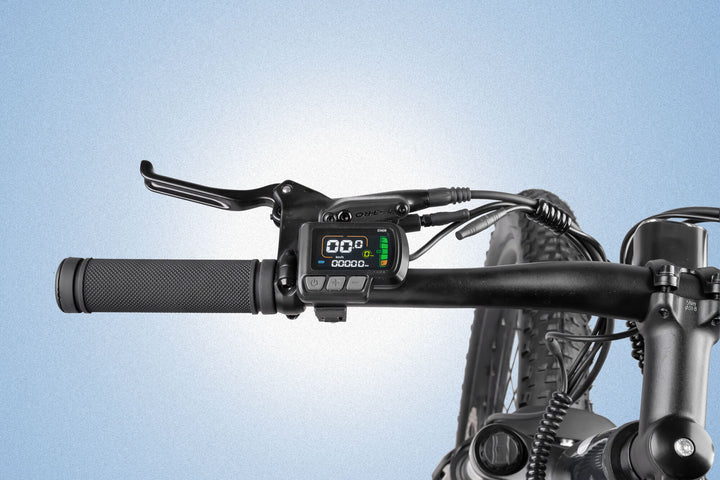 Close-up of an electric bicycle handlebar, showing a digital display with speed and battery indicators, a hand brake lever, and textured grip against a light blue gradient background.